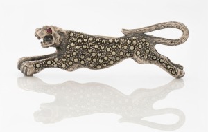 An Art Deco silver and marcasite panther brooch with ruby set eye, ​​​​​​​6.5cm wide, 20 grams