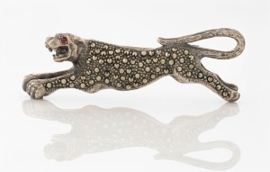 An Art Deco silver and marcasite panther brooch with ruby set eye, 6.5cm wide, 20 grams