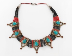 A tribal silver necklace adorned with polished turquoise, red stones and trade beads, 40cm long