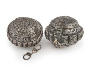 Two antique Malaysian silver tobacco boxes (Chelpa) of broadly spherical form with a shaped apron with scalloped edge. The domed sides with chased and repoussé decoration of trailing foliage centred with a leafy fluted rosette, all edged with a quatrefoil border. One side with a hinged clasp, releasing the hinged lid, each with a serrated locking pin. Negeri Sembilan, Malaysia, late 19th/early 20th century. 9 x 7cm and 8.5 x 6.5cm, 151 grams and 112 grams.