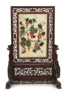 An antique Chinese jade and hard stone table screen in ornately carved timber stand 19th/20th century, 41cm high.