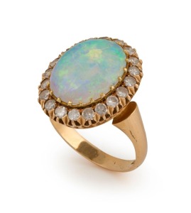 An 18ct yellow gold ring, set with a solid polished opal surrounded by brilliant cut white diamonds, stamped "750"