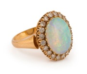An 18ct yellow gold ring, set with a solid polished opal surrounded by brilliant cut white diamonds, stamped "750" - 2