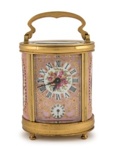 An antique French oval and porcelain panelled carriage clock timepiece with bell chiming alarm mechanism, gilt decorated dial and panels with musical motifs, circa 1900, engraved to the top "9 Août, 1906", 14cm high