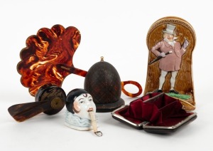 Novelty porcelain figural tape measure, mechanical pocket fan, tortoiseshell fan, Mauchline ware inkwell, Mr. Micawber point of sale porcelain match holder and an antique coin purse, 19th and 20th century, (6 items), ​​​​​​​the fan 20cm high