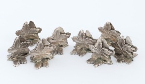 An antique set of eight place name holders, cast sterling silver in grape leaf form, 20th century, 120 grams total