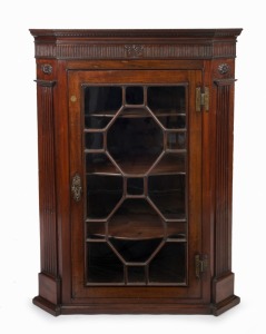 An antique English George III mahogany hanging corner cupboard, astragal glazed single door with original H-hinges, stop fluted pilasters to the cantered sides, fluted and acanthus carved frieze with ogee moulded corners, circa 1780, most likely the top of a free standing corner cupboard, 109cm high, 81cm wide, 50cm deep