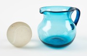 An unusual Murano glass tennis ball ornament with original circular label "Made in Murano, Italy"; together with an antique blue glass water jug, 19th and 20th century, (2 items), the jug 10cm high