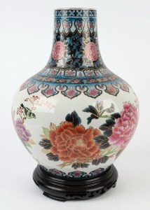 A Chinese porcelain vase decorated with peonies and birds, on carved wooden stand, late 20th century, 45cm high