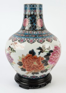 A Chinese porcelain vase decorated with peonies and birds, on carved wooden stand, late 20th century, ​​​​​​​45cm high