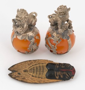 A pair of Tibetan silver and amber Foo Dog ornaments, together with a Chinese cicada ink cake, (3 items) the Foo Dogs 6cm high