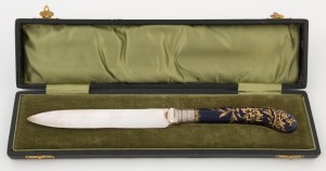 An antique blue and gilt porcelain handled knife with sterling silver collar and silver plated blade, housed in original plush fitted box, 19th century, the box 28cm wide