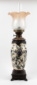 An antique oil lamp with floral porcelain stand and metal mounts with single burner (later shade and chimney), circa 1900, 72cm high overall