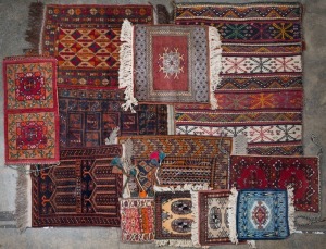 Twelve assorted hand-knotted Persian and tribal cushion covers and mats, the largest 98 x 74cm.