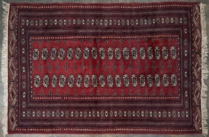 A Turkoman red and burgundy hand-knotted rug, 185 x 127cm.