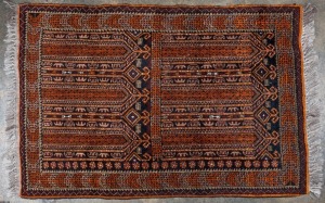 A hand-knotted tribal wool rug with orange highlights, 150 x 96cm