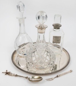 Sterling silver mounted decanter together with two other decanters, a silver plated tray, a Dutch silver spoon and a silver-plated pickle fork, 20th century, (6 items), the tray 35cm diameter