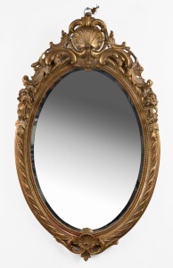 A gilt oval wall mirror in the Rococo style with beaded rope twist edge and scallop floral decoration, 20th century, 108cm high, 66cm wide