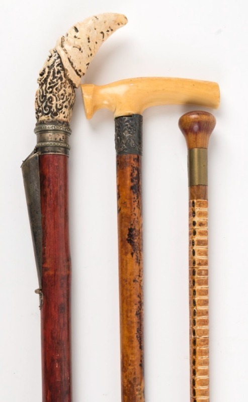 An antique walking stick with carved ivory handle, silver collar, Malacca cane shaft and brass ferrule, together with a shark vertebrae walking stick and a novelty walking stick with gnomes head handle, 19th/20th century, (3 items), the ivory handle examp