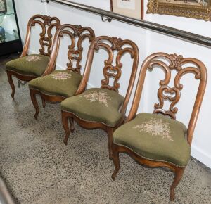A set of four antique carved walnut salon chairs with French cabriole legs and green floral tapestry upholstery, mid 19th century, 82cm high