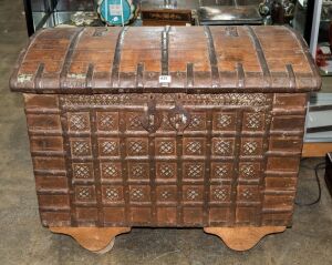 An antique Indo-Portuguese teak domed top dowry chest with iron strapping, 19th century, later wheels added, 79cm high, 97cm wide, 56cm deep