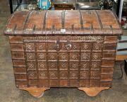 An antique Indo-Portuguese&nbsp;teak domed top dowry chest with iron strapping,&nbsp;19th century, later wheels added, 79cm high, 97cm wide, 56cm deep