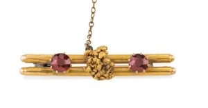 An antique Australian double bar brooch with gold nugget specimen flanked by cut stones, 19th century, 4.4cm wide, 6.8 grams