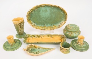 ERIC BRYCE CARTER gum leaf and gumnut green and yellow glazed pottery candle sticks, vase, ginger jar, pen tray, leaf dish, napkin ring and oval bowl, (8 items), all signed "E. Bryce Carter, Sydney, N.S.W.", the platter 26cm wide