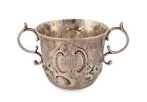 An 18th century CHANNEL ISLANDS silver Guernsey style christening cup by PIERRE AMIRAUX of Jersey, circa 1750, engraved with monogram and repousse floral decoration, 7cm high, 12.5cm wide, 132 grams