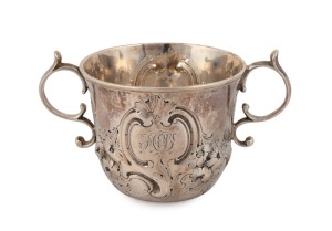 An 18th century CHANNEL ISLANDS silver Guernsey style christening cup by PIERRE AMIRAUX of Jersey, circa 1750, engraved with monogram and repousse floral decoration, 7cm high, 12.5cm wide, 132 grams
