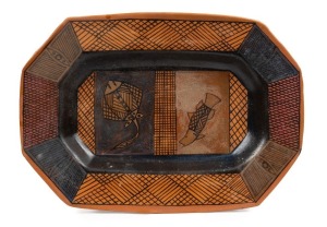 ROBERT EDWARD PURUNTATAMERI brown and black matte glazed pottery platter with painted stingray and barramundi decoration, 45cm wide