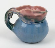 PHILIPPA JAMES pottery jug with applied gumnuts and leaf with branch handle, glazed in blue and green with pink interior and highlights, incised "Philippa James", 8cm high, 10cm wide