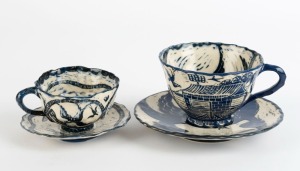 GERRY WEDD, two blue and white ceramic cups and saucers with hand-painted decoration, (4 items), both signed "WEDD, '07", the larger saucer 15.5cm wide