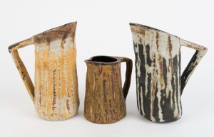 NINA MATHEWSON group of three studio pottery jugs with triangular form handles, ​​​​​​​the largest 20cm high