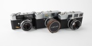 OLYMPUS: Three late 1950s rangefinder cameras - one Olympus Auto [#108199] with G. Zuiko 42mm f1.8 lens [#108605] and Olympus Auto metal lens hood, one Olympus Auto B [#102879] with E. Zuiko 42mm f2.8 lens [#102669], and one Olympus Auto Eye [#113895] wit