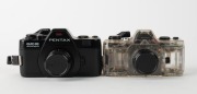 ASAHI KOGAKU: Two 110-cartridge SLR cameras - one c. 1979 Pentax Auto 110 with clear plastic body together with Pentax-110 24mm f2.8 lens [#1295813] and front lens cap, and one c. 1982 black-body Pentax Auto 110 Super with Pentax-110 24mm f2.8 lens [#1132 - 2