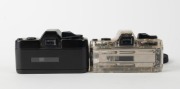 ASAHI KOGAKU: Two 110-cartridge SLR cameras - one c. 1979 Pentax Auto 110 with clear plastic body together with Pentax-110 24mm f2.8 lens [#1295813] and front lens cap, and one c. 1982 black-body Pentax Auto 110 Super with Pentax-110 24mm f2.8 lens [#1132 - 3