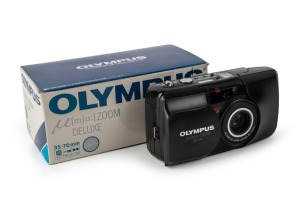 OLYMPUS: Mju Zoom Deluxe compact camera [#1328489] in black and silver, c. 1995, with Zoom 35-70mm lens in maker's box with branded camera pouch, RC-100 remote control, wrist strap, and instruction booklet.