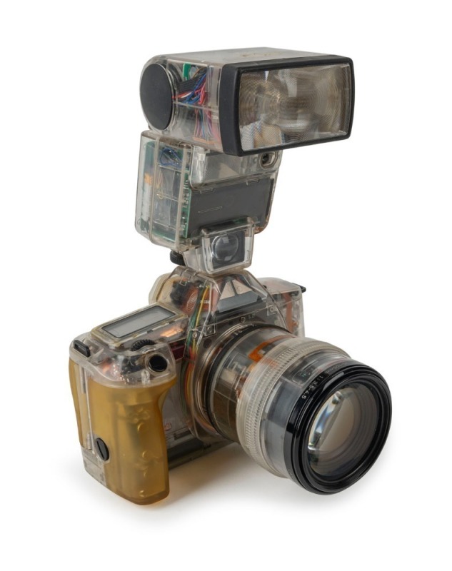 CANON: Transparent-body Canon EOS 650, c. 1987, with EF Zoom 35-105mm f3.5-4.5 lens, 420EZ battery-operated flash unit [#F055E], and rubber eyepiece attachment. Intended as a sales aid to illustrate the advantages of the EOS 650 to potential buyers.