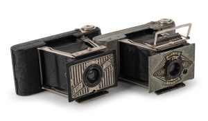 HOUGHTON: Two c. 1935 subminiature folding cameras - one Ensign Midget Silver Jubilee S55 with Ensar f6.3 Anastigmat lens, finished in silver enamel to commemorate the Silver Jubilee of King George V, together with one black-body Midget Model 22 with meniscus lens, maker's box, and warranty paper. (2 cameras)