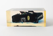 RIKEN: Circa 1980 point-of-sale display comprising one black Ricoh A-2 compact camera sealed in 16.5x7x11.5cm transparent plastic block. A publicity ploy that could not be effectively scaled due to excessive production costs. - 4