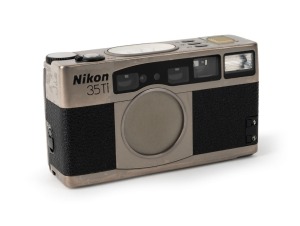 NIPPON KOGAKU: Nikon 35Ti titanium-chassis point-and-shoot camera [#US4018028], c. 1993, with Nikkor 35mm f2.8 lens. Featuring a unique set of analogue gauges that indicate focusing distance, aperture, frame number, and exposure compensation.