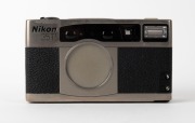 NIPPON KOGAKU: Nikon 35Ti titanium-chassis point-and-shoot camera [#US4018028], c. 1993, with Nikkor 35mm f2.8 lens. Featuring a unique set of analogue gauges that indicate focusing distance, aperture, frame number, and exposure compensation. - 2