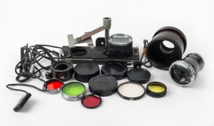 LEITZ: Seventeen accessories - five different lens filters, one VALOO hood, one OOZAB slide copier, one LVFOO magnifier, one VXOOT adapter, two IZQOO Leica M mount rear lens caps, two other lens caps, two MICOO-type flash sync cables, and two CNOOS-type sync cables. (17 items)