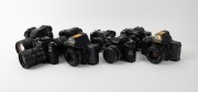 VARIOUS MANUFACTURERS: Eight black SLR cameras - one Canon PowerShot Pro1 with lens hood and lens cap, one Konica Minolta Dynax 5D with lens hood, one Minolta Maxxum 7000 AF with front lens cap, one Olympus Camedia E-10, one Ricoh KR-10, one Voigtl&auml;nder V - 2