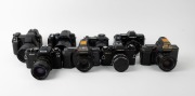 VARIOUS MANUFACTURERS: Eight black SLR cameras - one Canon PowerShot Pro1 with lens hood and lens cap, one Konica Minolta Dynax 5D with lens hood, one Minolta Maxxum 7000 AF with front lens cap, one Olympus Camedia E-10, one Ricoh KR-10, one Voigtl&auml;nder V - 3