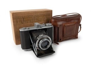 OLYMPUS: Chrome Six II vertical-folding camera [#34865], c. 1948, with Zuiko Coated 75mm f2.8 lens [#59760] and Copal lens. Presented with leather case in maker's wooden box that features etched text on lid.