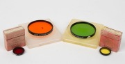 LEITZ: Four lens filters - one FIRHE Gelbfilter 1 in maker's box and&nbsp;one FCZOO Rotfilter Hell also in maker's box, together with two c. 1964 Serie VII lens filters in plastic cases - one in green with&nbsp;GGr designation, and one in orange with Or designation