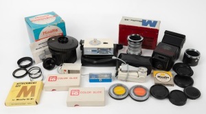 MINOLTA: An accumulation of twenty-six photography accessories, many in maker's boxes or leather pouches, including eight lens filters, two lens hoods, six lens caps, four flash units, one self-timer, one set of extension tubes, among several others. (26 items)