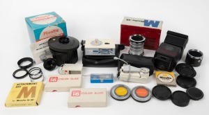 MINOLTA: An accumulation of twenty-six photography accessories, many in maker's boxes or leather pouches, including eight lens filters, two lens hoods, six lens caps, four flash units, one self-timer, one set of extension tubes, among several others. (26 